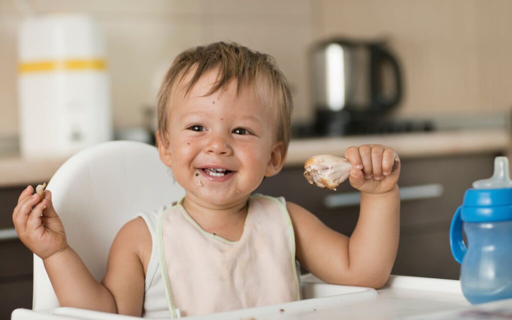 Baby eating chicken in the BLW method